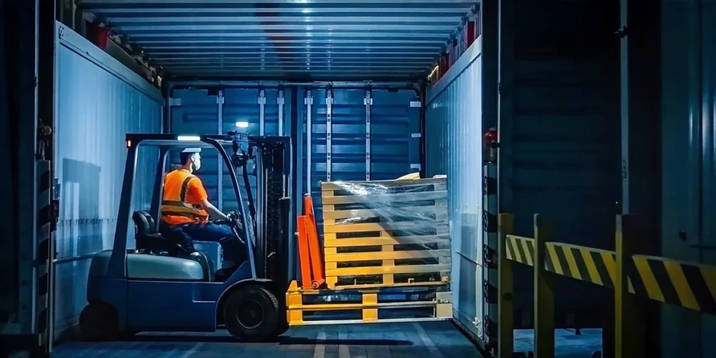 Warehouse worker inspecting a leaning pallet load in a freight trailer, industrial safety setting
